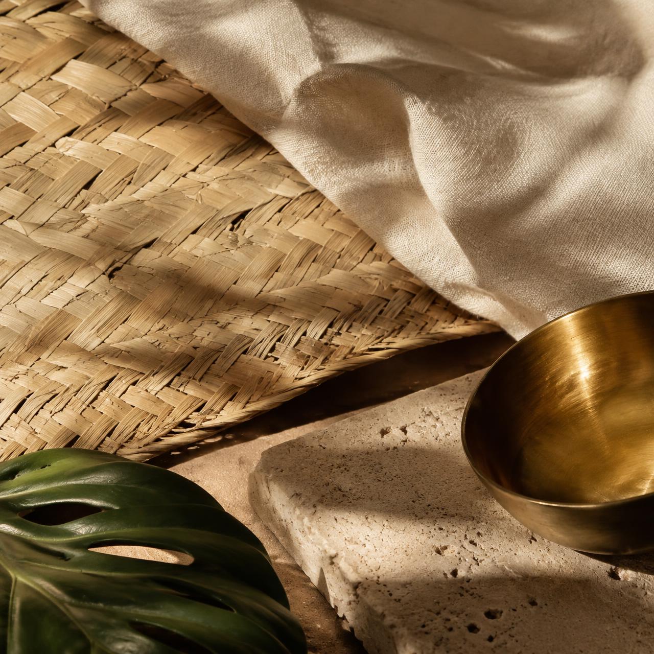 Natural materials: woven palm, linen, travertine and brass